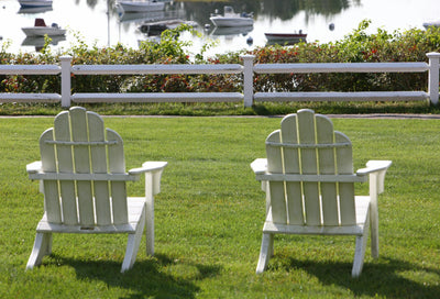 Outdoor lounge chairs set on a green lawn in daylight