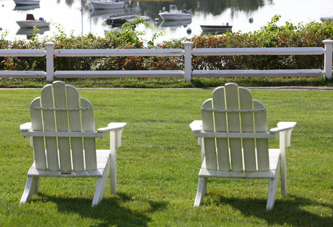 Outdoor lounge chairs set on a green lawn in daylight