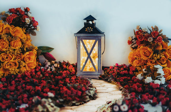 Outdoor lantern set among flowers beside a stone garden path